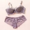 Beautiful female underwear. purple lace panties and bra lying on pink background